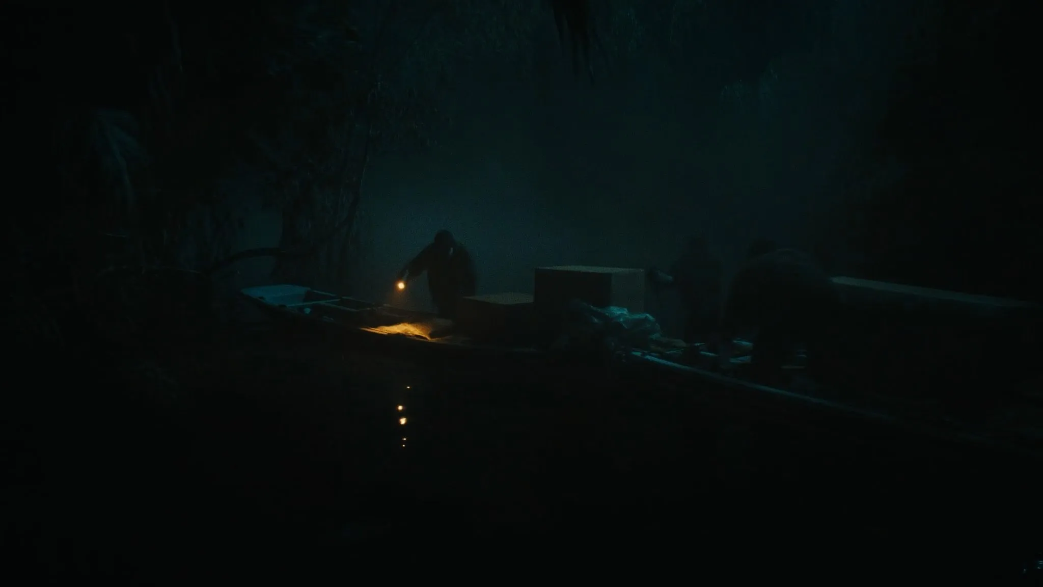 Two boats meeting in a mangrove cove at night to transfer cargo.